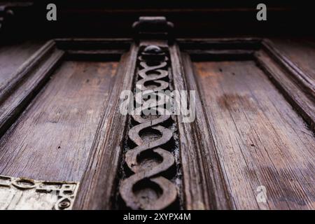 Sfondo vintage. Elementi di una vecchia porta in legno intagliato decorati con voluminosi elementi in legno intagliato che imitano la tessitura. Un concetto vintage di Foto Stock