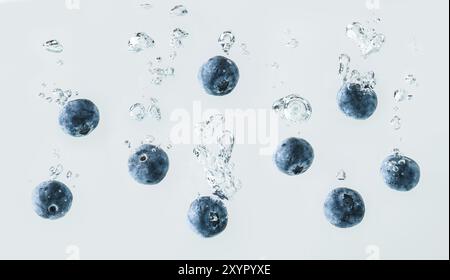 I mirtilli che affonda nell'acqua con bolle di aria sullo sfondo Foto Stock
