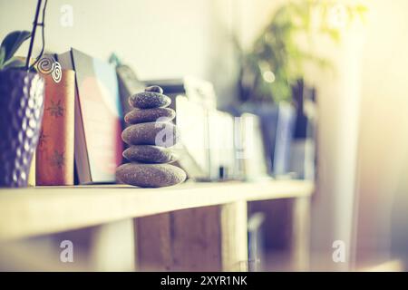 Feng Shui: Cairn di pietra in primo piano, salotto sfocato sullo sfondo. Equilibrio e relax Foto Stock