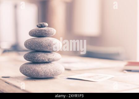 Feng Shui: Cairn di pietra in primo piano, salotto sfocato sullo sfondo. Equilibrio e relax Foto Stock