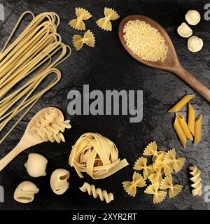 Una foto aerea di diversi tipi di pasta, compresi gli spaghetti, penne, fusilli, e altri, ripresa dall'alto su uno sfondo nero con un posto per Foto Stock