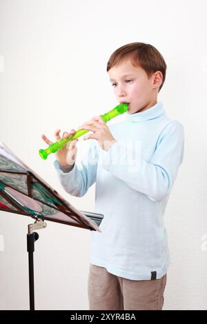 Il bambino intelligente suona il flauto Foto Stock