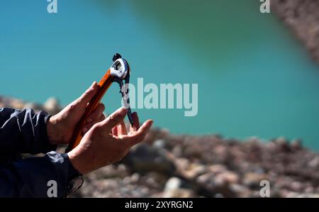 Arrampicatore con l'ascia di ghiaccio in montagna. Foto Stock