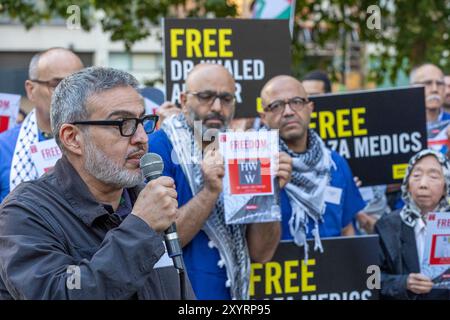 Protesta di solidarietà di massa per i medici palestinesi detenuti che si terrà fuori da St Thomas' Hospital Square, all'angolo tra Royal Street e Lambeth Palace Road, di fronte all'ingresso A&e del St Thomas' Hospital, Londra Regno Unito. Venerdì 30 agosto. 173 operatori sanitari in scrub medici si inginocchiano in una potente veglia per evidenziare la situazione degli operatori sanitari palestinesi detenuti dalle forze israeliane. C'è stata una richiesta per il rilascio del dottor Khaled al Serr, un chirurgo detenuto dalle forze israeliane presso l'ospedale Nasser di Khan Younis nel marzo 2024. Gli operatori medici hanno anche chiesto una sospensione immediata delle armi del Regno Unito Foto Stock