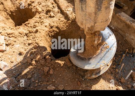 Macchina perforatrice idraulica per pali di alesaggio presso il cantiere. Foratura nel terreno. Fondamenta pila. Foto Stock