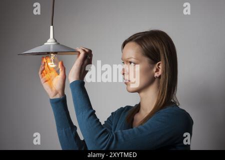 Donna con una lampadina bianca Foto Stock