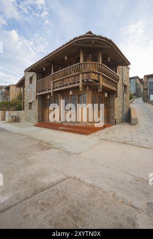 Una tradizionale casa in mattoni con un tipico balcone curvo in legno nel villaggio di Renai sull'isola di Nangan sull'arcipelago Matsu a Taiwan. Verticale Foto Stock