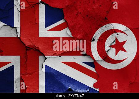 Bandiere del Regno Unito e della Tunisia dipinte su una parete incrinata Foto Stock