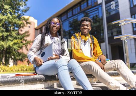 Ritratto con vista dall'angolo basso di due fantastici studenti afroamericani del campus universitario Foto Stock