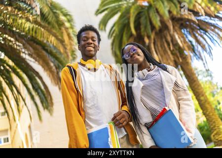 Vista dall'angolo basso ritratto di due studenti afroamericani che sorridono orgogliosi nel campus Foto Stock