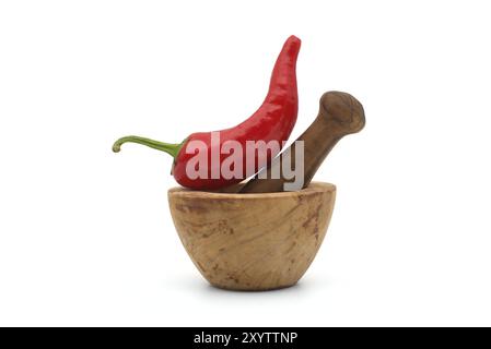 Peperoncino rosso fresco e vecchio pestello rustico in legno con mortaio isolato su sfondo bianco Foto Stock