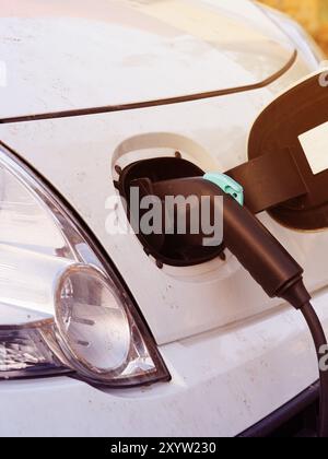 Dettaglio di un elettrico vehivle su di una stazione di carica, emissione libera concetto guida Foto Stock