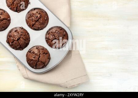 Una foto aerea di muffin al cioccolato in una padella, girato dalla parte superiore su uno sfondo luminoso con spazio di copia Foto Stock