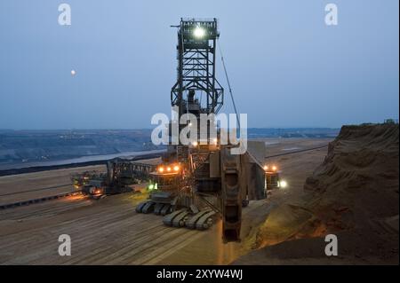 Escavatore gommato a benna escavatore gommato nelle ore blu nelle miniere a cielo aperto Foto Stock