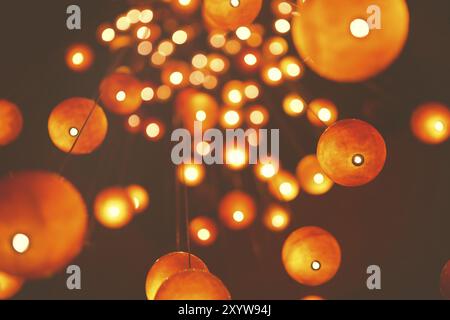 Dal basso delle lanterne rotonde rosse luminose e appese su sfondo scuro sfocato Foto Stock