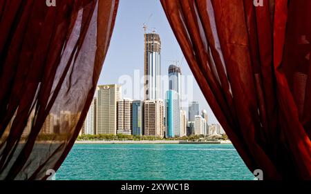 Vista dalla finestra dello skyline di Abu Dhabi sul Golfo Persico. Foto Stock