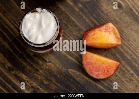 yogurt con marmellata e pezzetti di nettarina matura, yogurt naturale in un vaso di vetro con frutta Foto Stock
