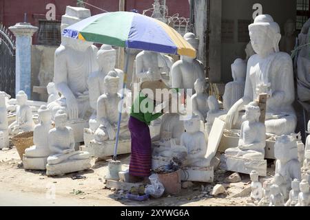 Donna che lucidano una statua del Buddha Foto Stock