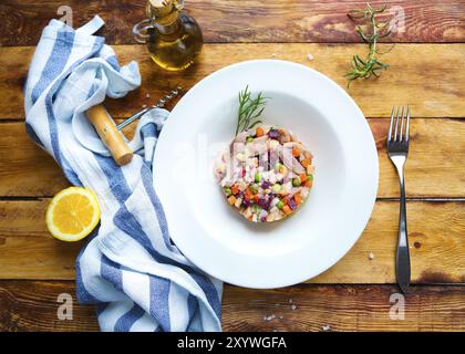 Tradizionale insalata russa aringa sotto una pelliccia sul tavolo di legno Foto Stock