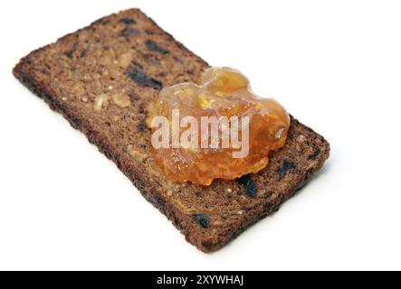 Un pezzo di pane con marmellata d'arancia su sfondo bianco Foto Stock