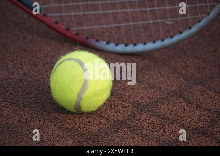 Ombre di racquet che circondano una palla da tennis vicino alla linea bianca sul campo all'aperto in sole, sport e concetto di stile di vita attivo Foto Stock