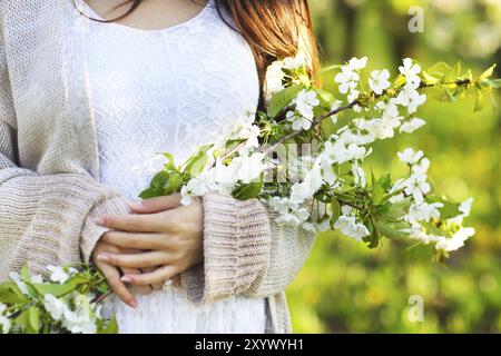 Concetto di bellezza. In prossimità delle mani della donna oltre il giardino di primavera e la fioritura dei ciliegi sfondo Foto Stock