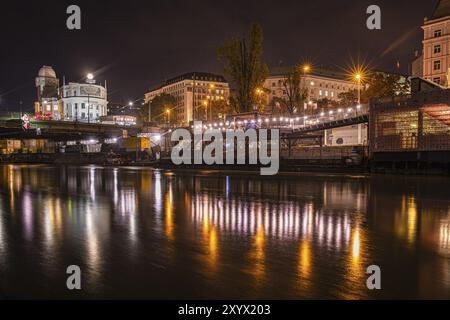 Le luci si riflettono nel canale del Danubio, sullo sfondo l'osservatorio illuminato di Urania, ripresa notturna, Vienna, Austria, Europa Foto Stock