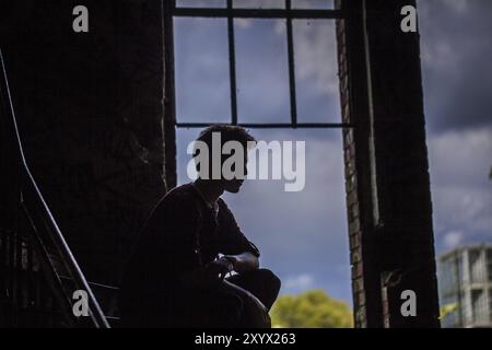 Silhouette di un adolescente in un edificio fatiscente Foto Stock