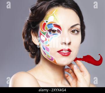 Ritratto di una giovane e bella modello con bright make up e spruzzi di colore Foto Stock