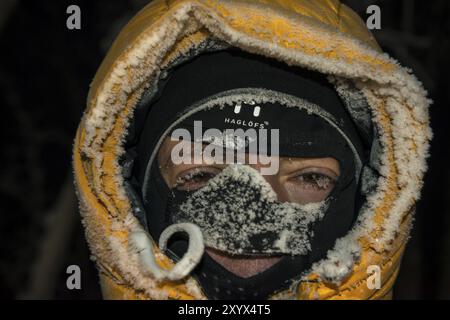 Uomo con cappuccio coperto di ghiaccio e balaclava, Abisko, Norrbotten, Lapponia, Svezia, dicembre 2012, Europa Foto Stock