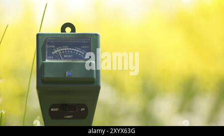 Misuratore di umidità del suolo, intensità luminosa e PH in primo piano, concetto di tecnologia agricola Foto Stock