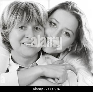 Bianco e nero close up ritratto di una coppia madre e figlia adulta essendo vicino e abbracciando a casa di essere felice e gioiosa Foto Stock