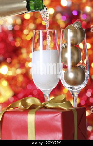 Lo champagne che viene versato a bicchieri a sfondo di Natale Foto Stock