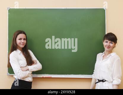 Le ragazze dello studente in piedi vicino a lavagna in classe Foto Stock