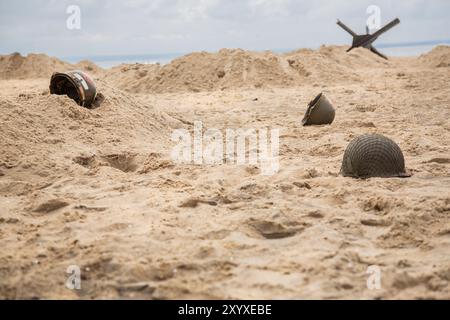 Tre caschi di fanteria americana M1 dalla seconda guerra mondiale sulla spiaggia. Foto Stock