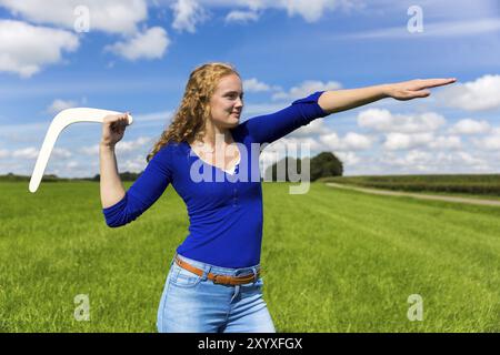 Giovane donna caucasica gettando boomerang in natura Foto Stock