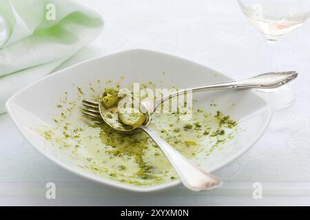 Primo piano della mangiato linguine piastra con pesto genovese, patate e vino bianco vetro Foto Stock