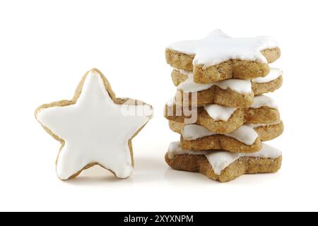 Biscotti di Natale, pila di stelle di cannella, una sola in piedi, in germania chiamato zimtsterne, isolatet da vicino su sfondo bianco Foto Stock