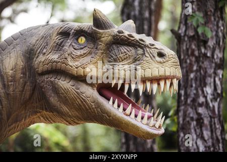 Tempi preistorici dinosauro a piedi la foresta che mostra la sua bocca toothy Foto Stock