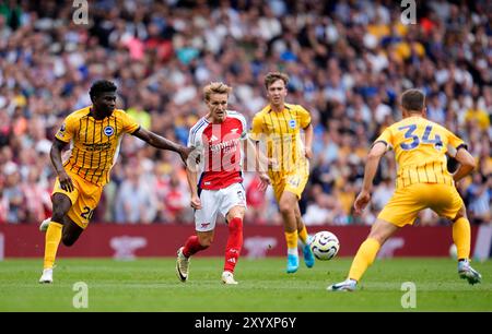 Martin Odegaard (centro) dell'Arsenal combatte per il pallone con Carlos Baleba (sinistra) e Joel Veltman (destra) di Brighton & Hove Albion durante la partita di Premier League all'Emirates Stadium di Londra. Data foto: Sabato 31 agosto 2024. Foto Stock