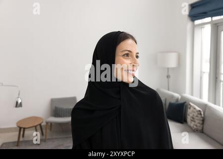 Bella donna araba felice che posa in casa Foto Stock