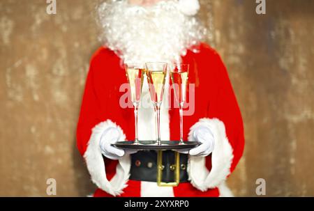 Santa Claus holding champagne bicchieri sul vassoio. Primo piano Foto Stock