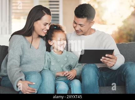 Genitori, ragazza e tablet per film divertenti a casa, abbonamento online e Risate per la commedia. Famiglia, figlia e sito Web per guardare video o. Foto Stock