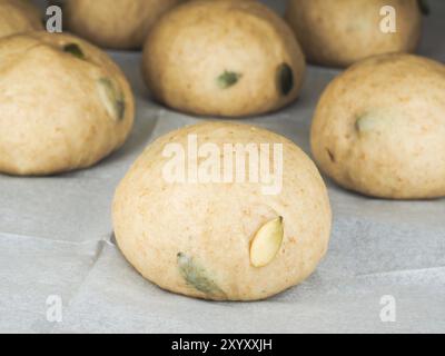 Panini di semi di zucca su carta da forno a distanza ravvicinata Foto Stock