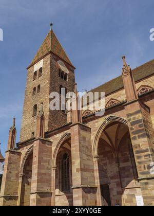 Chiesa gotica con torre alta, archi suggestivi e dettagli in pietra sotto un cielo limpido, Weissenburg, Alsazia, Francia, Europa Foto Stock