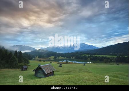 Capanna in legno o prato presso il lago Geroldsee all'alba, vista sulle Alpi Karwendel Foto Stock