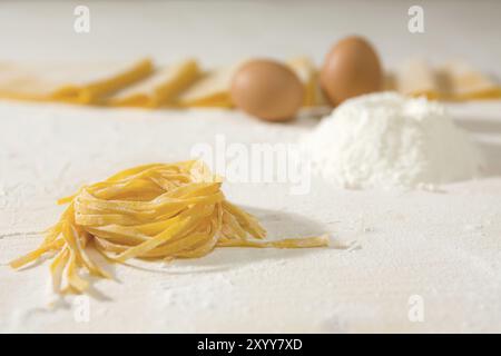 Primo piano di carni non cotte le tagliatelle in una tabella e uova e frumento su sfondo Foto Stock