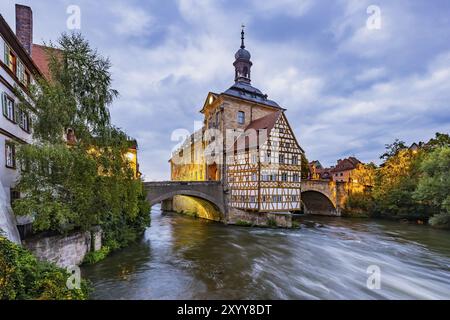 Vecchio municipio su un'isola artificiale sul fiume Regnitz. Il punto di riferimento può essere raggiunto tramite due ponti ad arco. Ripresa notturna. Vista sulla città di Bamberga, Uppe Foto Stock