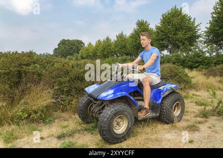 Giovane uomo olandese la guida quad nel verde della natura Foto Stock