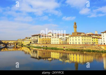 Vista sulla città con la torre di Palazzo Vecchio, le case e il Ponte Vecchio che si riflette sul fiume Arno, Firenze, Italia, Europa Foto Stock